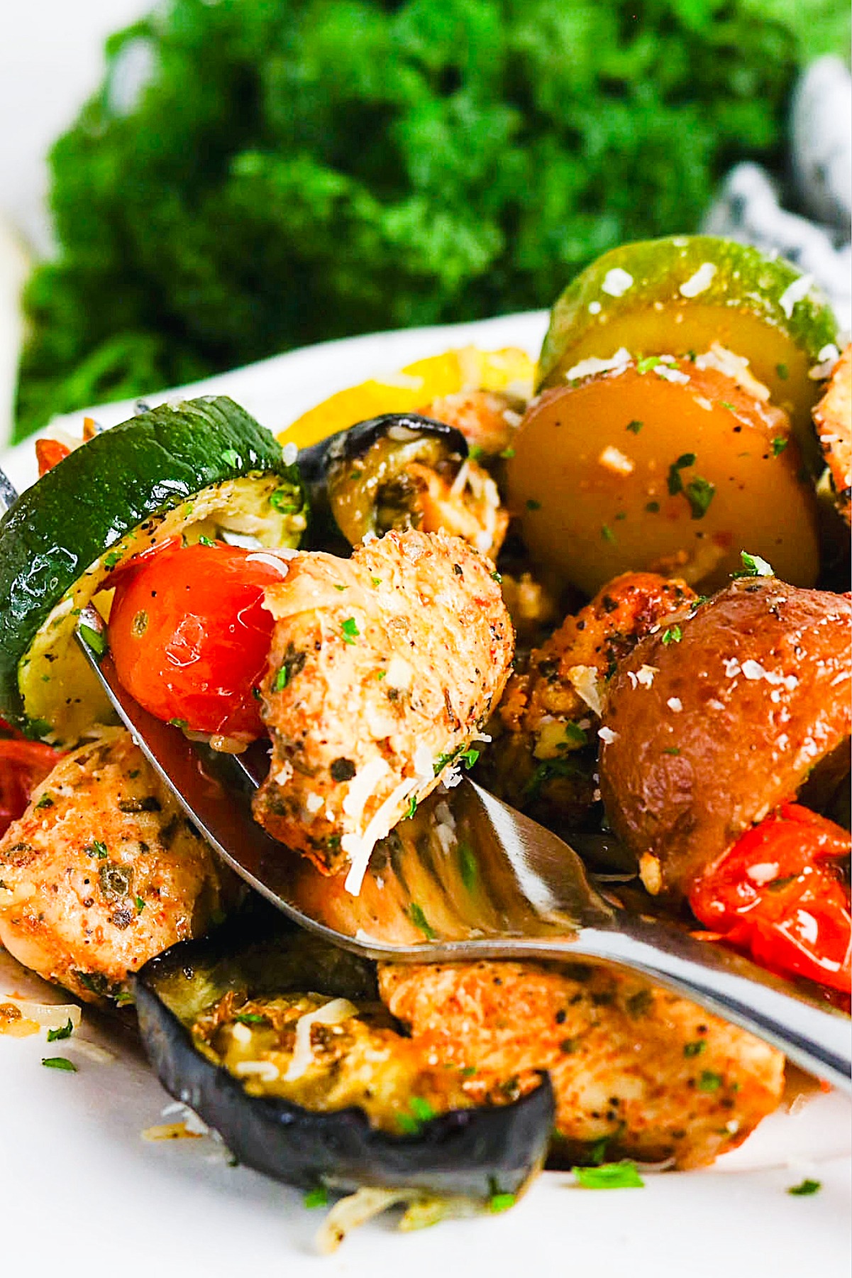 Forkful of chicken, cherry tomato, and squash.